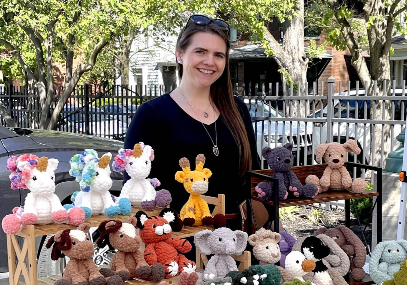 Leah Hooks at a market table filled with handmade crochet plushies